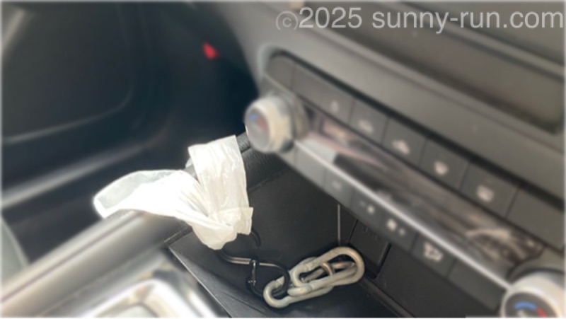 CX-5のシフトレバー前方の空間にカラビナを置き、つなげたストッパー付きS字フックにレジ袋を吊り下げて、車内ゴミ箱として使用している。