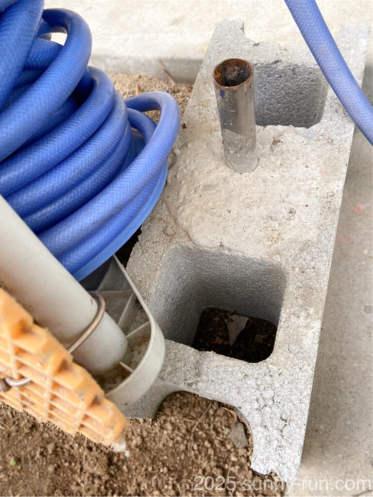 ホースリール回転台の土台となるコンクリートブロックと、軸受けとなるステンレス製の筒